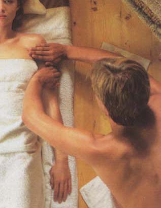 Massage strijking met vlakke handen op de bovenarm tot aan de schouder voor het ontspannen van de huid