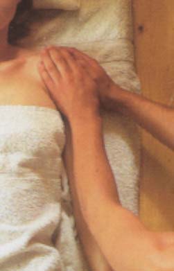 Detail van de positie van de handen bij de massage van de schouder met glijdende handen rondom het schoudergewricht