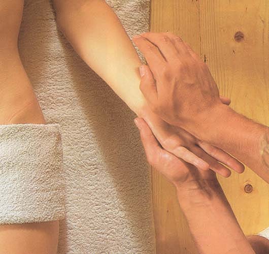De ondersteunde handpalmen worden met de bal van de hand van de masseur volledig gemasseerd. Detailfoto van de massage.