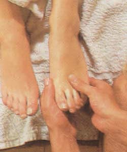 Sensuele diepere voetmassage met de vingers bij de aanzet van de tenen met gewrichtsmassage. Detailbeeld